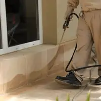 General pest control technician spraying exterior perimeter around a home in Cincinnati, OH