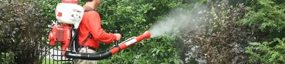Mosquito control technician fogging shrubs and landscaping for mosquito treatment in Cincinnati, OH